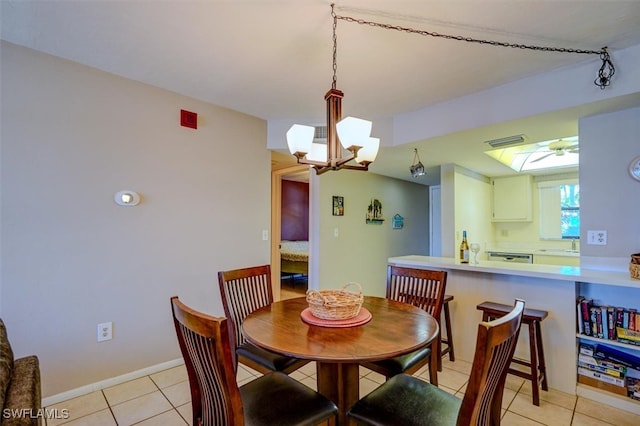 dining area with a notable chandelier, light tile patterned floors, and sink