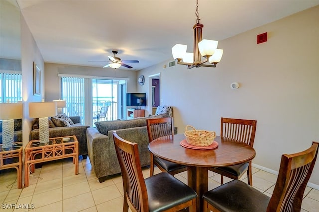 tiled dining area featuring ceiling fan with notable chandelier