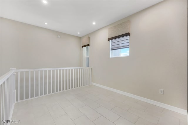 empty room featuring baseboards and recessed lighting