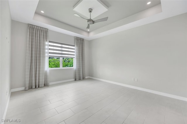 unfurnished room featuring a tray ceiling and baseboards