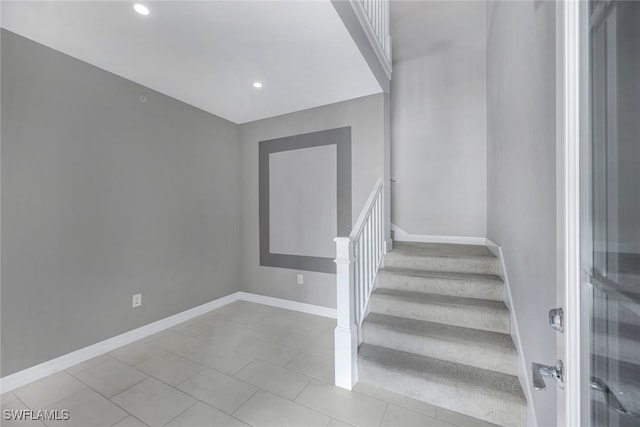 staircase featuring tile patterned flooring, baseboards, and recessed lighting