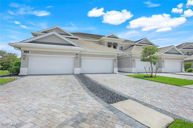 view of front of home with decorative driveway and stucco siding