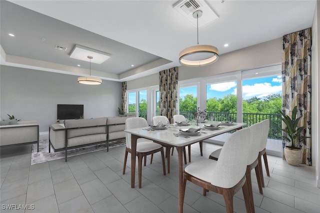 dining space with light tile patterned floors, a raised ceiling, visible vents, and recessed lighting