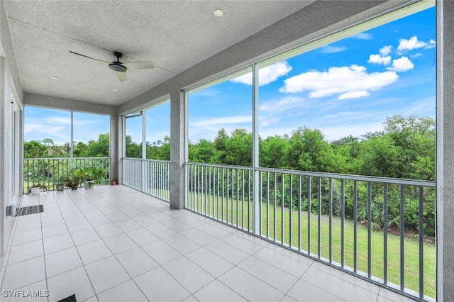 unfurnished sunroom featuring a ceiling fan