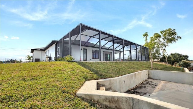 rear view of property with glass enclosure, a yard, and cooling unit