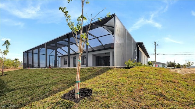 back of house featuring a lawn and glass enclosure