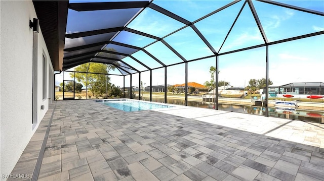 pool with a lanai, a water view, and a patio