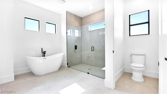 full bath with baseboards, a soaking tub, a stall shower, tile patterned floors, and toilet