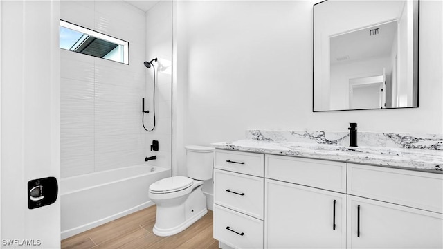 bathroom featuring visible vents, toilet, wood finished floors, bathtub / shower combination, and vanity