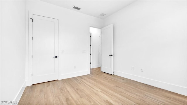 unfurnished bedroom with light wood-type flooring, visible vents, and baseboards