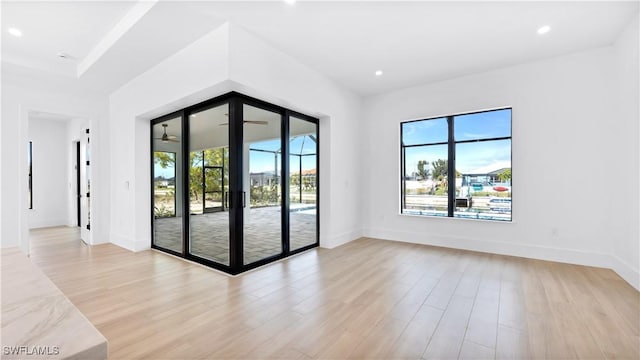 empty room with recessed lighting, light wood-style flooring, and baseboards