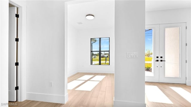 entryway featuring light wood finished floors and french doors