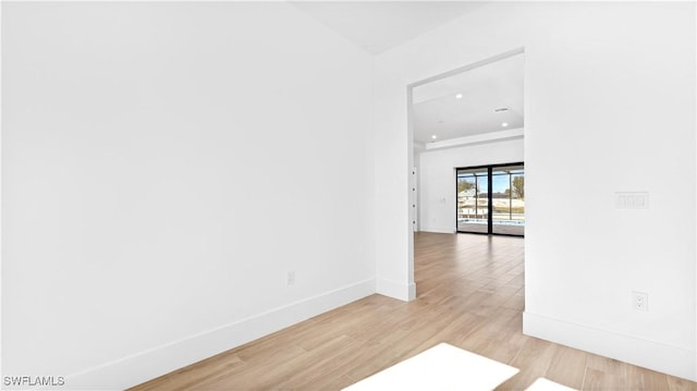 spare room featuring recessed lighting, light wood-type flooring, and baseboards