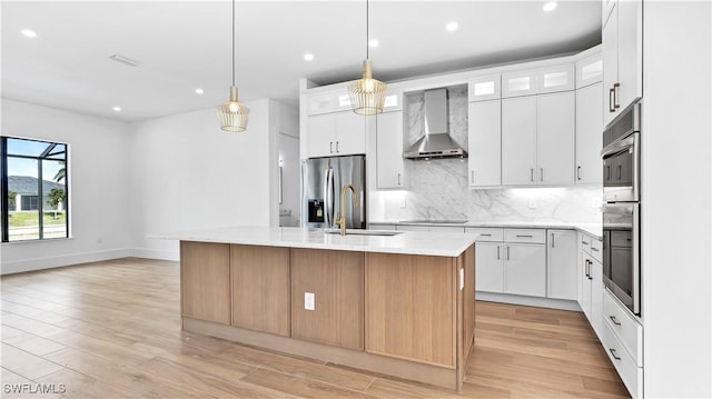 kitchen with stainless steel refrigerator with ice dispenser, black electric stovetop, backsplash, a sink, and wall chimney range hood