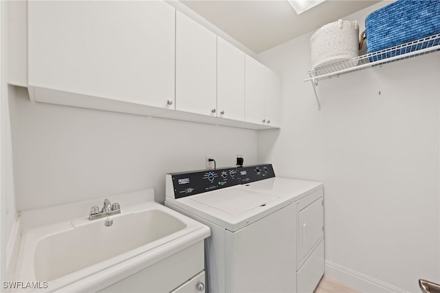 washroom with washer and dryer, cabinets, sink, and light hardwood / wood-style flooring