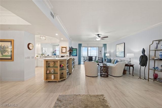 living room featuring ceiling fan, light wood-type flooring, and crown molding