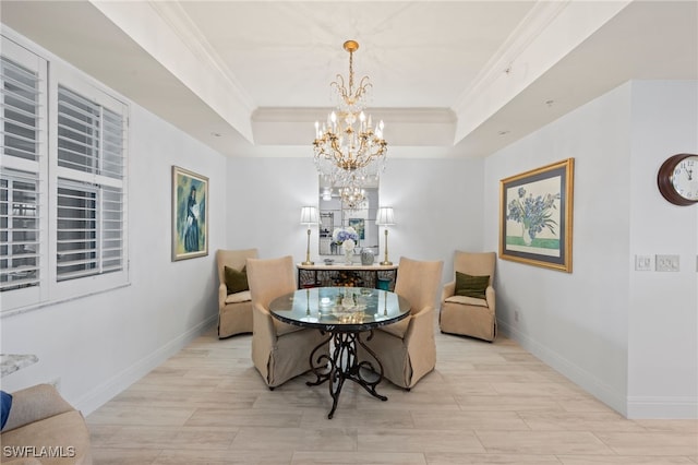 dining area featuring a raised ceiling, crown molding, and a chandelier