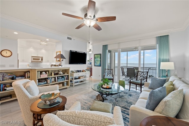 living room featuring crown molding, light hardwood / wood-style floors, and ceiling fan with notable chandelier