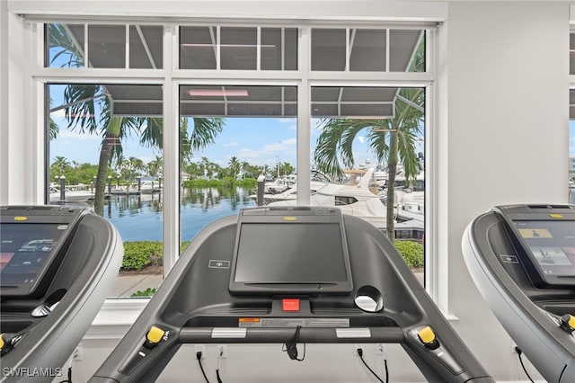 exercise room featuring a water view and a wealth of natural light