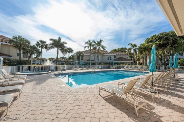 pool featuring a patio area, a hot tub, and fence