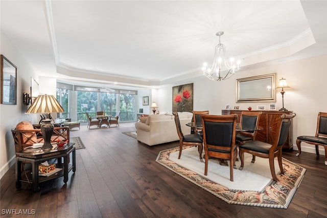 dining space with dark wood-style floors, baseboards, a tray ceiling, and a chandelier