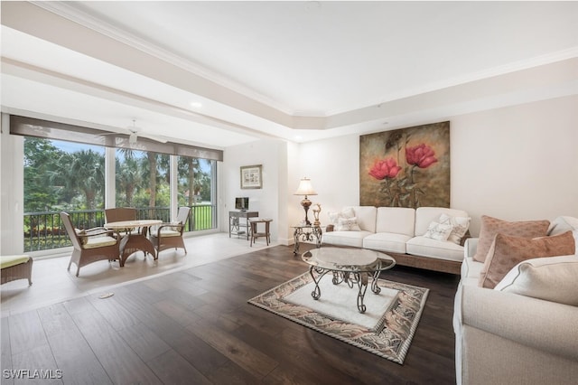 living room featuring ornamental molding, baseboards, and wood finished floors