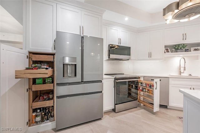 kitchen with white cabinetry, appliances with stainless steel finishes, light countertops, and a sink