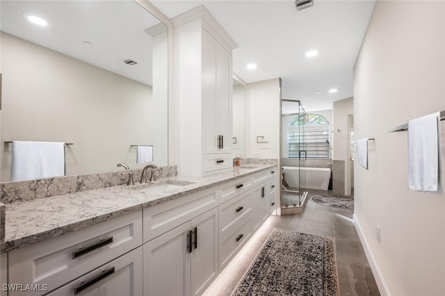 full bath featuring a freestanding tub, recessed lighting, baseboards, and vanity