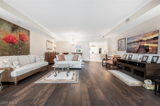 living room with hardwood / wood-style flooring, visible vents, and an inviting chandelier