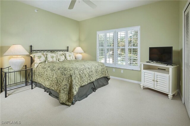 bedroom featuring ceiling fan, a closet, and light carpet