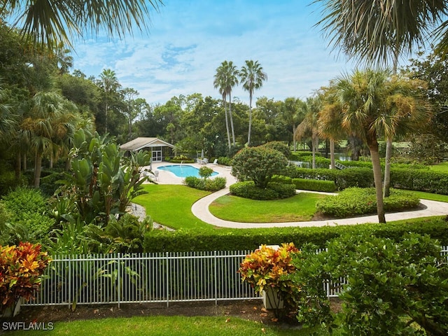 surrounding community featuring fence, a pool, and a yard