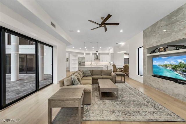 living room featuring light hardwood / wood-style flooring and ceiling fan