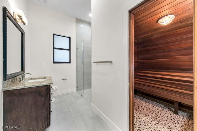 bathroom featuring vanity, toilet, and an enclosed shower