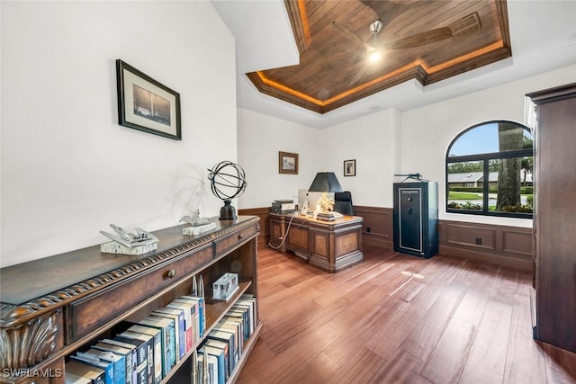 office space featuring ornamental molding, wood-type flooring, wooden ceiling, and a raised ceiling