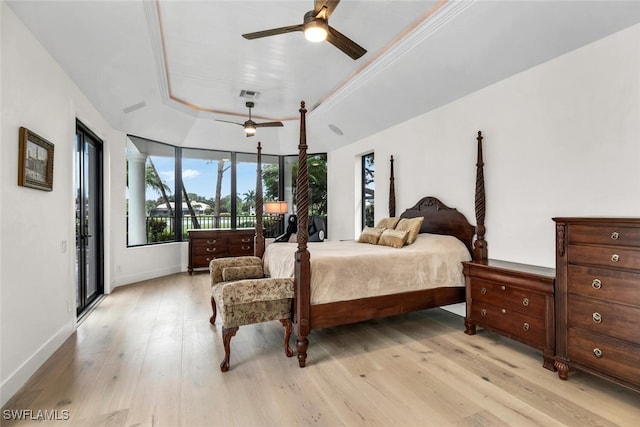 bedroom with a raised ceiling, light hardwood / wood-style floors, ceiling fan, and access to outside