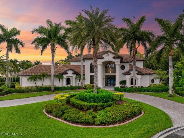 mediterranean / spanish-style home with french doors and a lawn