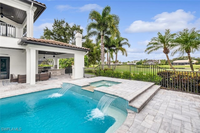 view of swimming pool featuring an in ground hot tub, pool water feature, a patio area, and ceiling fan