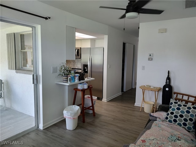 living room featuring ceiling fan and dark hardwood / wood-style floors