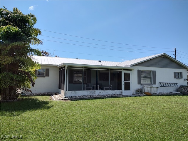 rear view of house with a lawn, a sunroom, and a wall unit AC