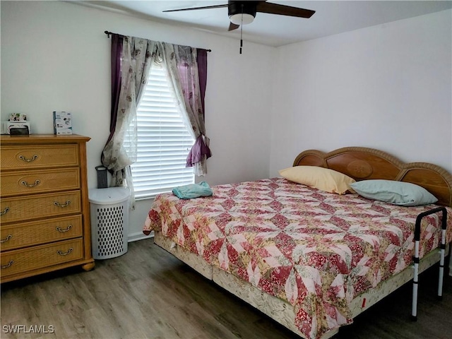 bedroom featuring multiple windows, dark hardwood / wood-style floors, and ceiling fan