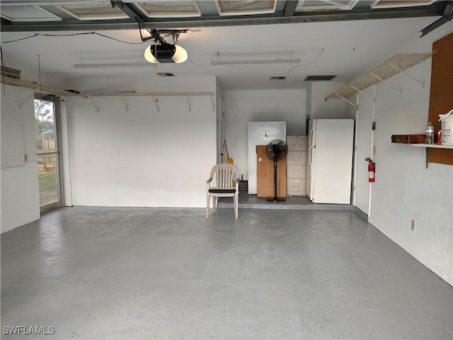 garage with a garage door opener and white fridge