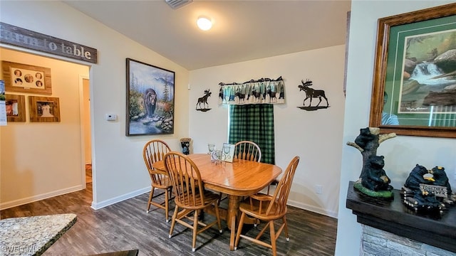 dining room with lofted ceiling and dark hardwood / wood-style floors