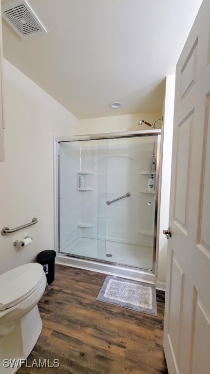 bathroom with walk in shower, hardwood / wood-style floors, and toilet