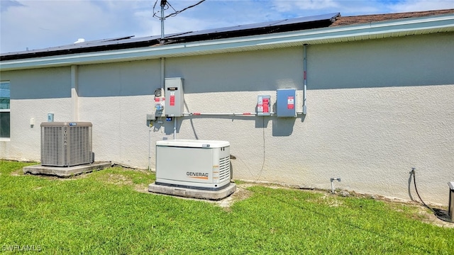 exterior space with central AC unit, solar panels, and a lawn