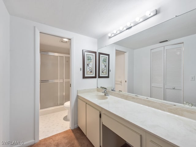 bathroom with an enclosed shower, vanity, and toilet