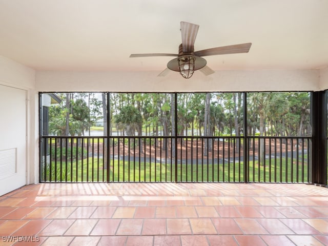 unfurnished sunroom with ceiling fan