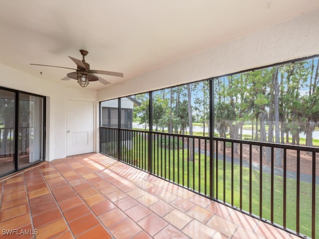 unfurnished sunroom with a water view and ceiling fan