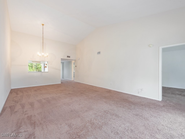 spare room featuring carpet, lofted ceiling, and an inviting chandelier