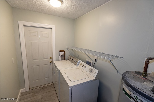 laundry area with laundry area, wood finished floors, a textured ceiling, water heater, and separate washer and dryer