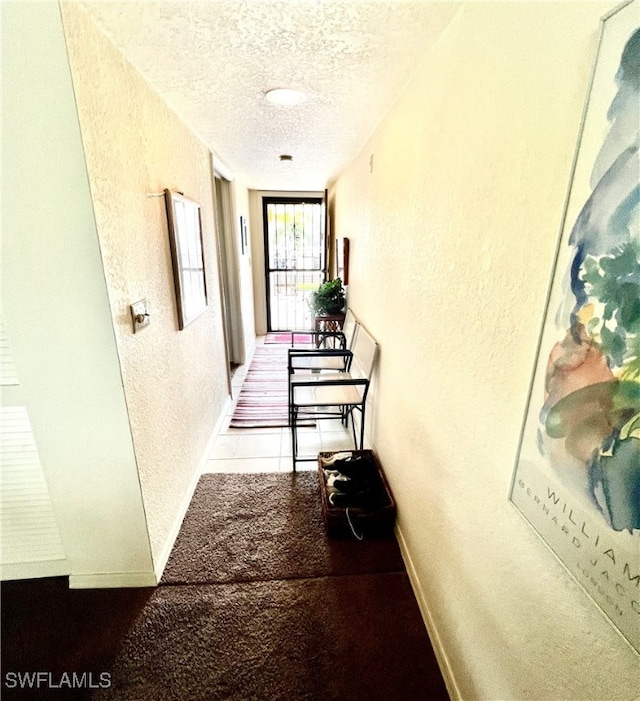 corridor featuring a textured ceiling and carpet